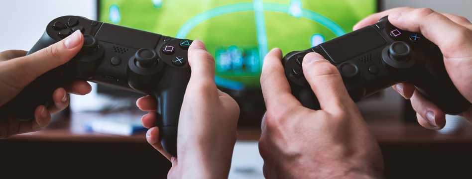 game controllers held in front of tv screen